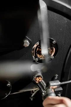 Coffee processing. Roastery, roasting machine and fresh beans Stock Photos