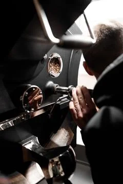 Coffee processing. Roastery, roasting machine and fresh beans Stock Photos