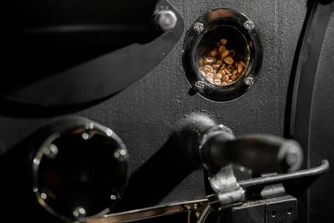 Coffee processing. Roastery, roasting machine and fresh beans Stock Photos