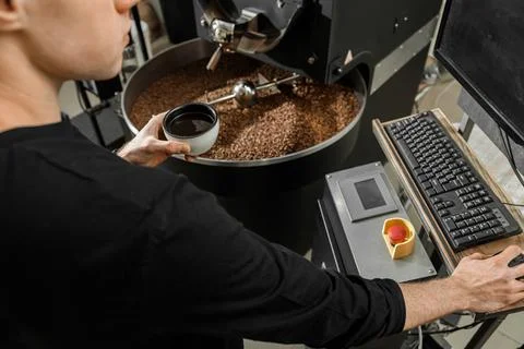 Coffee processing. Roastery, roasting machine and fresh beans Stock Photos