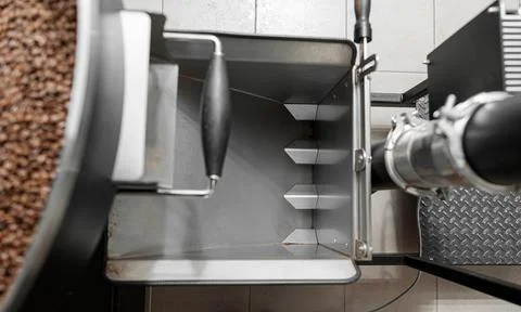 Coffee processing. Roastery, roasting machine and fresh beans Stock Photos