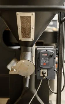 Coffee processing. Roastery, roasting machine and fresh beans Stock Photos