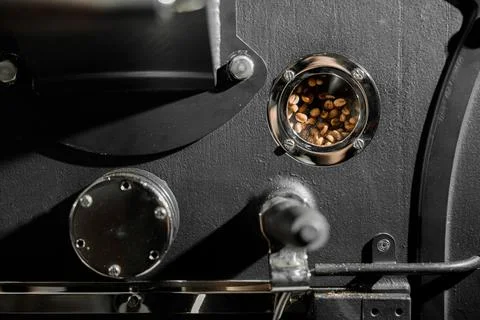 Coffee processing. Roastery, roasting machine and fresh beans Stock Photos