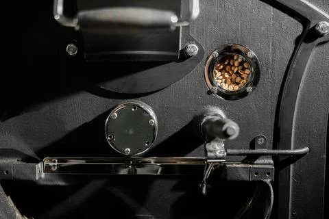 Coffee processing. Roastery, roasting machine and fresh beans Stock Photos