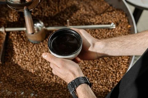 Coffee processing. Roastery, roasting machine and fresh beans Stock Photos