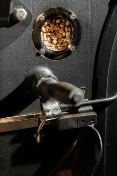 Coffee processing. Roastery, roasting machine and fresh beans Stock Photos