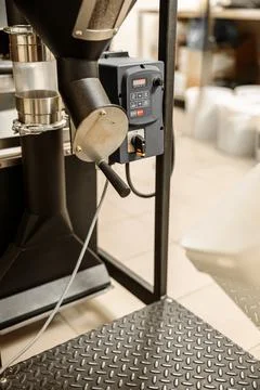 Coffee processing. Roastery, roasting machine and fresh beans Stock Photos