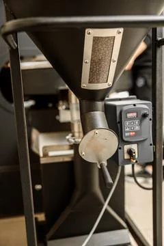 Coffee processing. Roastery, roasting machine and fresh beans Stock Photos