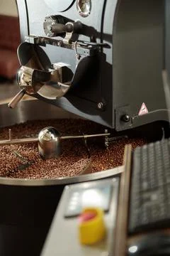 Coffee processing. Roastery, roasting machine and fresh beans Foto stock