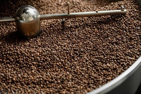 Coffee processing. Roastery, roasting machine and fresh beans Stock Photos