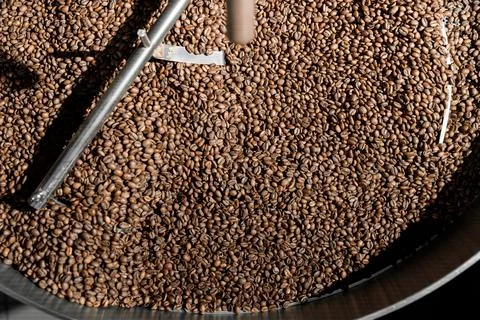 Coffee processing. Roastery, roasting machine and fresh beans Stock Photos