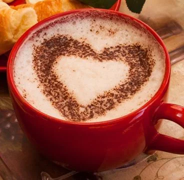 Coffee in red mug with hearth shape cocoa dust for valentines day Foto stock