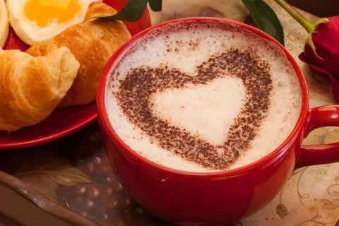 Coffee in red mug with hearth shape cocoa dust for valentines day Stock Photos