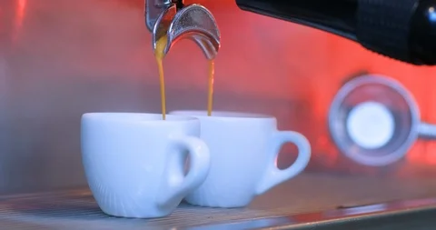 Coffee running through the coffee machine filter holder for two cups of coffee Stockbeeldmateriaal 122371576