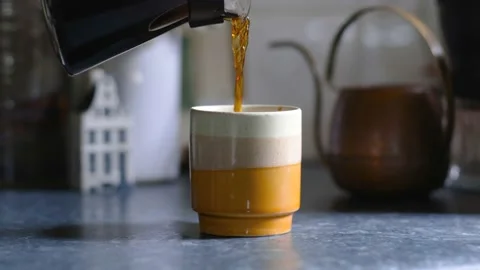 Coffee server (carafe) pouring coffee into small mug Video stock 166485787