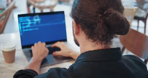 Coffee shop coding concept. A programmer sitting in a bustling coffee shop Stock Footage 258661812