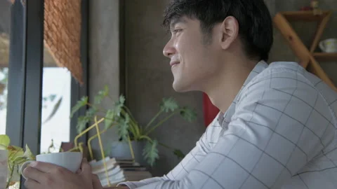 Coffee shop concept of 4k Resolution. Young Asian man happily drinking coffee Stock Footage 147452292