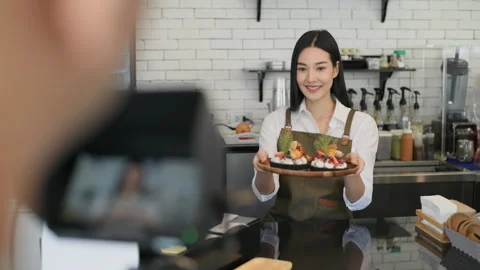 Coffee shop concept of 4k Resolution. Asian female employee holding a cake re Stock Footage 213457026
