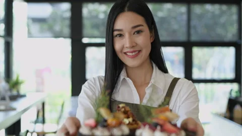 Coffee shop concept of 4k Resolution. Asian female employee confidently han.. Stock Footage 248860393