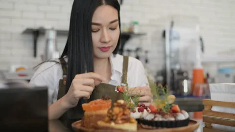Coffee shop concept of 4k Resolution. Asian girls decorating cakes in stores. Video stock 256890571