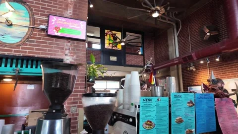 Coffee shop counter features bean grinders and menus. Stock Footage 333917414