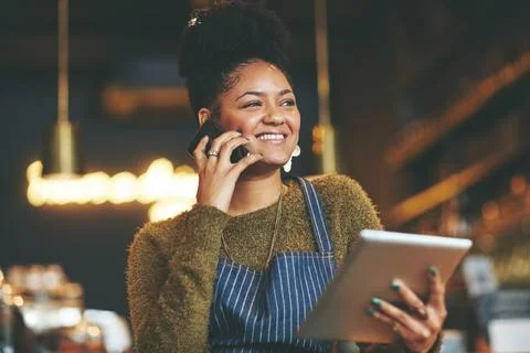 Coffee shop management made simpler with smart tech. a young woman using a phone Stock Photos