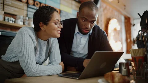 Coffee Shop Owner Using Laptop with Barista Stock Footage 143734833