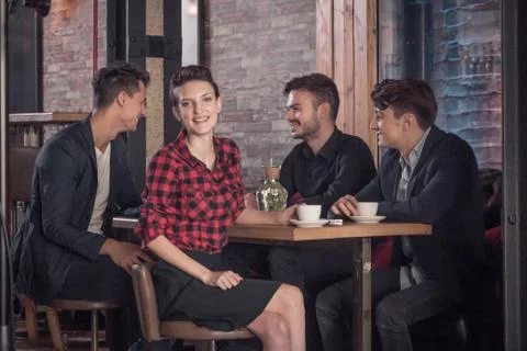 Coffee shop table, small group of people talking, sitting in bar stool, wom.. Stock Photos