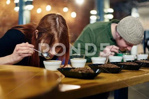 Coffee Shop Team Smelling Bowls Of Coffee And Coffee Beans At Tasting