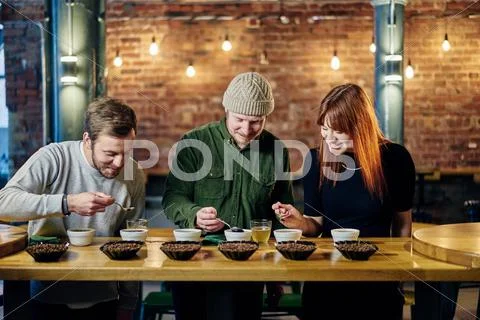 Coffee Shop Team Tasting Bowls Of Coffee And Coffee Beans