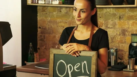 A coffee shop worker holds a Open sign. Stock Footage 95393699