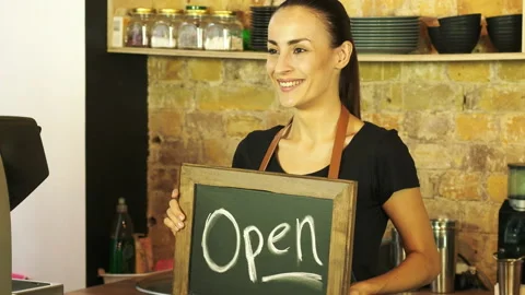 A coffee shop worker holds a Open sign. Stock Footage 95428406