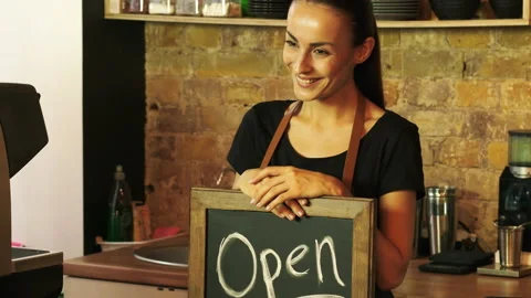 A coffee shop worker holds a Open sign. Stock Footage 96104503