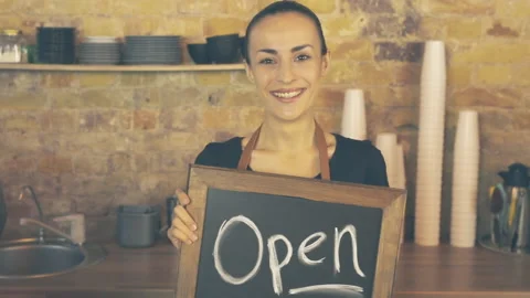 A coffee shop worker holds a Open sign. Stock Footage 96104943