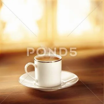 Coffee in silver-rimmed cup and saucer Stock Photos