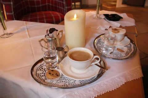 Coffee with Silver on Table with Candle Foto stock