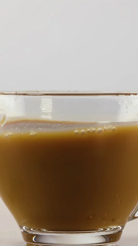 Coffee Sloshing and Swirling Inside Clear Glass Mug Stock Footage 346595684