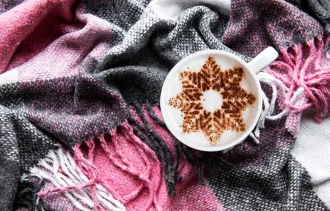 Coffee with a snowflake pattern on a warm woolen plaid Foto stock