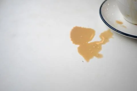 Coffee spill on table near empty cup at cafe Stock Photos