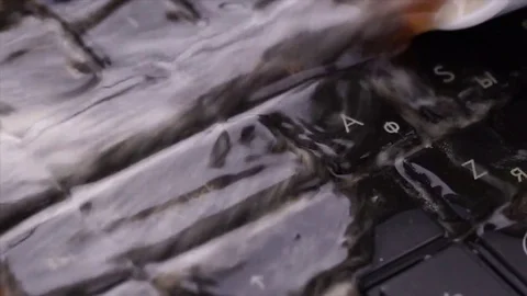Coffee spilled over the keyboard notebook slow motion close-up Stock Footage 72526097