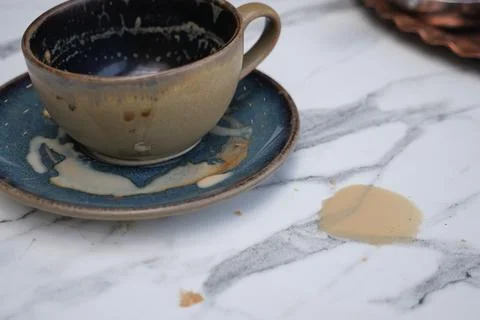 Coffee spills while resting on a marble table surface Stock Photos