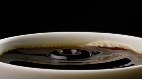 Coffee splashing inside a cup from falling drops Stock Footage 316072013