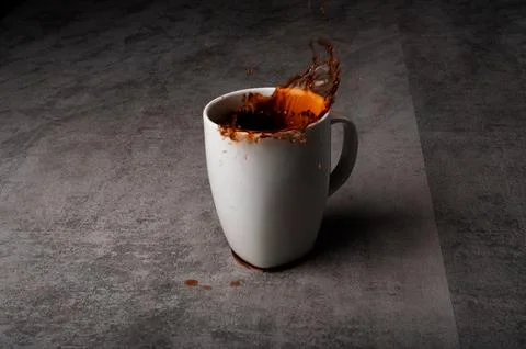 Coffee Splashing Up from Mug on Table Stock Photos