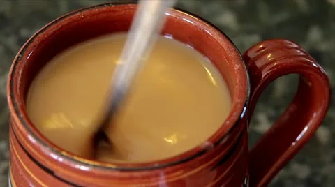 Coffee is Stirred in a Mug with a Silver Spoon (swirling action) Stock Footage 11081944