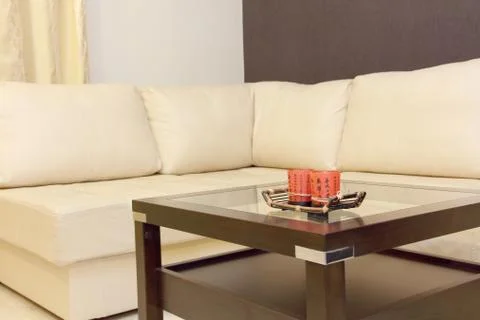 Coffee table and white corner leather sofa . Stock Photos