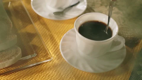 Coffee Table with Bolo de Rolo, Steam, White Cup, Hand Stirring with Spoon Stock Footage 303519118