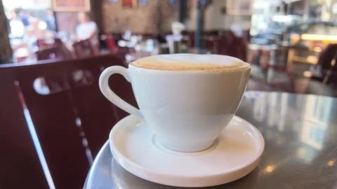 Coffee on a table in a cafe during the daytime with people around Stock Photos