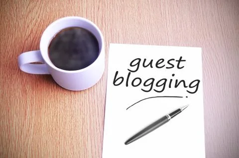 Coffee on the table with note writing guest blogging Foto stock