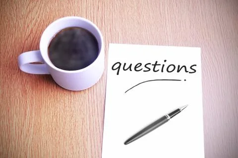 Coffee on the table with note writing questions Foto stock