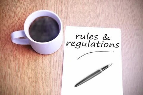 Coffee on the table with note writing writing rules &amp; regulations Foto stock